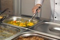 School canteen worker at serving line. Tasty food