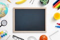 School chalkboard mockup on work desk. Composition of a student`s desk with stationery items, toys, snack