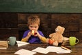 School change. School break. Hungry kid biting apple in classroom. Small boy playing with paper plane and teddy bear