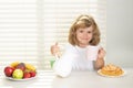 School chil pouring whole cows milk for breakfast. Kid preteen boy 7, 8, 9 years old eating healthy food vegetables Royalty Free Stock Photo