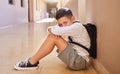 School child, bullying and sad student on ground for depression, anxiety and autism or learning problem in hallway. Boy