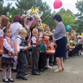 School child with gifts, flowers and balloons in their hands and the teacher at the holiday knowledge day