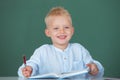 School child student learn lesson sitting at desk studying. Kid writing in notebook in class. Education and kids Royalty Free Stock Photo