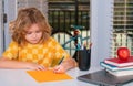 School child studying writing school homework at home. Kid from elementary school. Child pupil doing homework in her Royalty Free Stock Photo