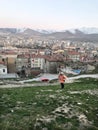 A school child walking at grass and behind Nigde city center