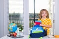 School child 7-8 years old with book go back to school. Little student doing homework at home, puts school supplies in a Royalty Free Stock Photo