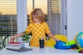 School child 7-8 years old puts school supplies in a backpack go back to school. Little student doing homework at home. Royalty Free Stock Photo