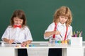 School children drawing a colorful pictures with pencil crayons in classroom on blackboard background. Portrait of cute Royalty Free Stock Photo