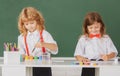 School children drawing a colorful pictures with pencil crayons in classroom on blackboard background. Portrait of cute Royalty Free Stock Photo