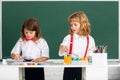 School children drawing a colorful pictures with pencil crayons in classroom. Cute pupils enjoying art and craft lesson. Royalty Free Stock Photo