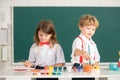 School children drawing a colorful pictures with pencil crayons in classroom. Portrait of cute pupils enjoying art and Royalty Free Stock Photo