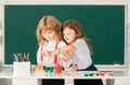 School children drawing a colorful pictures with pencil crayons in classroom. Portrait of cute pupils enjoying art and Royalty Free Stock Photo