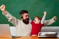 School children. Hurray. Father and son. Child showing winner sign. Chalkboard ready for text