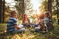 Kids raising hands asking questions during outdoor lesson with teacher in forest on sunny spring day Royalty Free Stock Photo