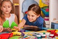 School children with scissors in kids hands cutting paper .