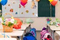 School class on September 1 without students with colorful balloons and flowers on desks against the background of the school boar Royalty Free Stock Photo