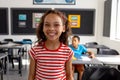 In school, in the classroom, a biracial girl and boy are focusing on learning