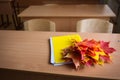 School classroom. notebook and bouquet of autumn maple leaves on the table. concept: back to school, teacher`s day Royalty Free Stock Photo