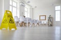 School classroom where cleaning service worker placed sign which reads Caution Wet Floor Royalty Free Stock Photo