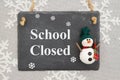 School Closed message on a chalkboard sign with a snowman Royalty Free Stock Photo