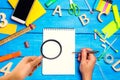 school concept, accessories. the schoolboy points to a notepad. hand with magnifying glass. new ideas, homework solution. back to Royalty Free Stock Photo