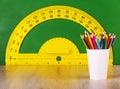 School concept colore penciil and yellow protractor on green chalkboard. Royalty Free Stock Photo