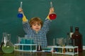 School concept. Education. Cheerful smiling little boy having fun against blue wall. They carried out a new experiment Royalty Free Stock Photo