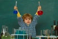 School concept. Education. Cheerful smiling little boy having fun against blue wall. They carried out a new experiment Royalty Free Stock Photo