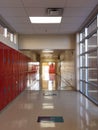 school empty hall with a row of bright red student lockers, manÃ¢â¬â¢s reflection going down the stairs Royalty Free Stock Photo