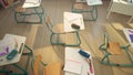 School desks and chairs in classroom. Wooden desks with school supplies