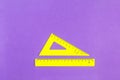 School drawing tools. Yellow triangle and ruler on a purple background Royalty Free Stock Photo