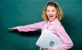 School education concept. School lecturer explaining topic. Woman adorable teacher hold laptop stand near chalkboard