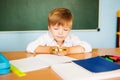 School and education concept. Little children at school lesson. Happy student writing in notebook in school classroom Royalty Free Stock Photo