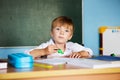 School and education concept. Little children at school lesson. Happy student writing in notebook in school classroom Royalty Free Stock Photo