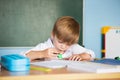 School and education concept. Little children at school lesson. Happy student writing in notebook in school classroom Royalty Free Stock Photo