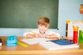 School and education concept. Little children at school lesson. Happy student writing in notebook in school classroom Royalty Free Stock Photo