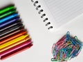 colored metalic clips, colored crayon row and note book with spiral, background and texture