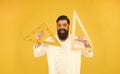 School of engineering. Happy engineer or designer. Smart engineer holding triangles on yellow background. Teaching Royalty Free Stock Photo