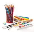 School equipment with pencils, notebook, paints and brushes on white. Back to school concept