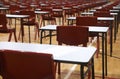 School exam room or hall set up with multiple tables, desks and chairs