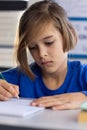 In school, focused boy writing in notepad during classroom activity Royalty Free Stock Photo