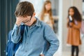 School friends bullying a sad boy in corridor at school Royalty Free Stock Photo