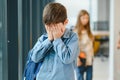 School friends bullying a sad boy in corridor at school Royalty Free Stock Photo