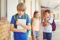 School friends bullying a sad boy in corridor Royalty Free Stock Photo