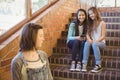 School friends bullying a sad girl in school corridor Royalty Free Stock Photo