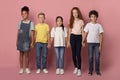 School friendship. Adorable multiethnic children holding hands together over pink background
