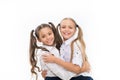 School friendship is so special. Adorable small friends hugging isolated on white. Happy schoolgirls enjoying friendship