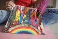 Girl draws rainbow with melted crayon pencils, she using blow dryer and wax stars to melt, art idea