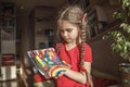 Girl draws rainbow with melted crayon pencils, she using blow dryer and wax stars to melt, art idea Royalty Free Stock Photo