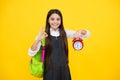 School girl and education concept. Back to school. Schoolchild, teenage student girl with backpack and clock alarm, time Royalty Free Stock Photo